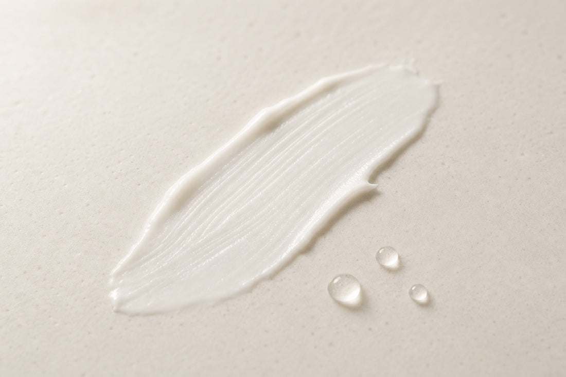 A light swipe of white cream with water droplets on warm ceramic