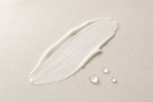 A light swipe of white cream with water droplets on warm ceramic