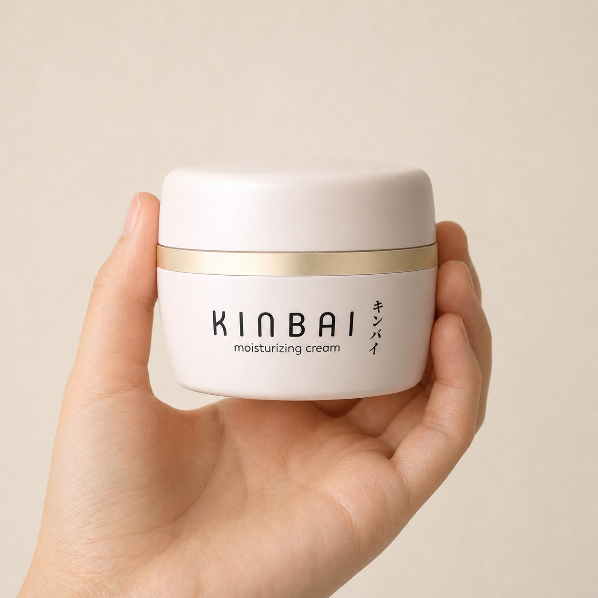 Kinbai Moisturizing Cream jar held in a hand, showing its size